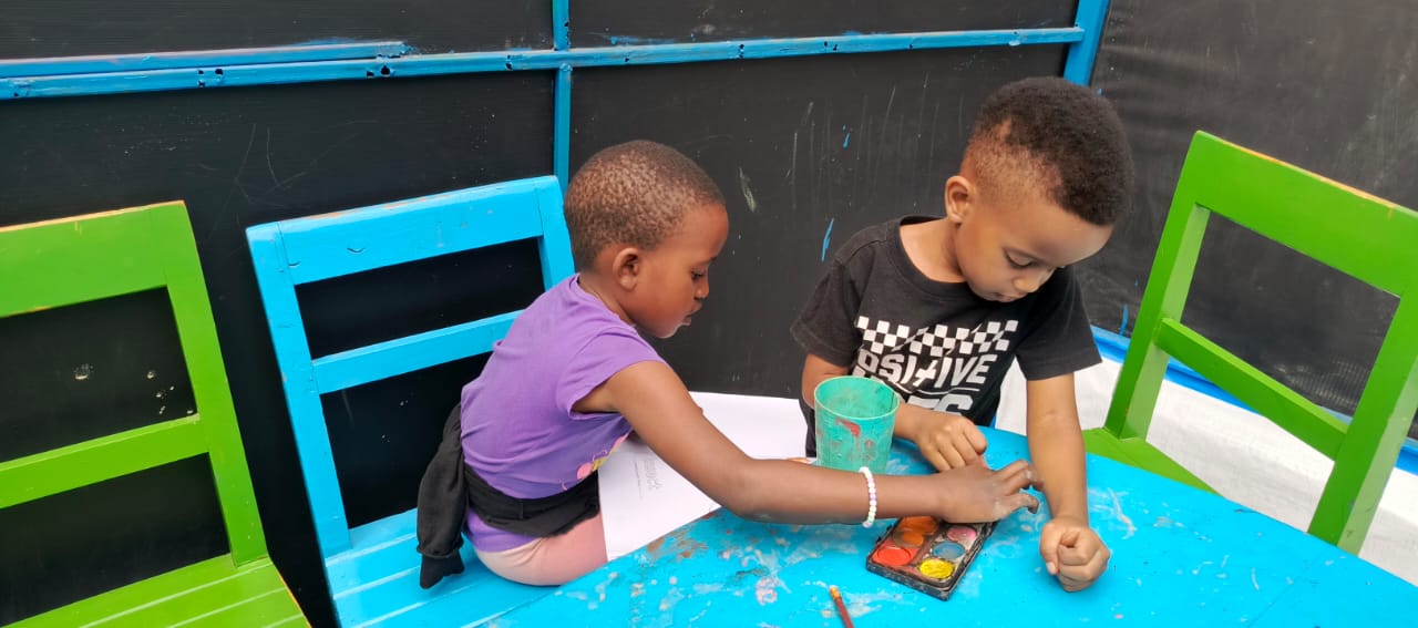 Children painting together at a table