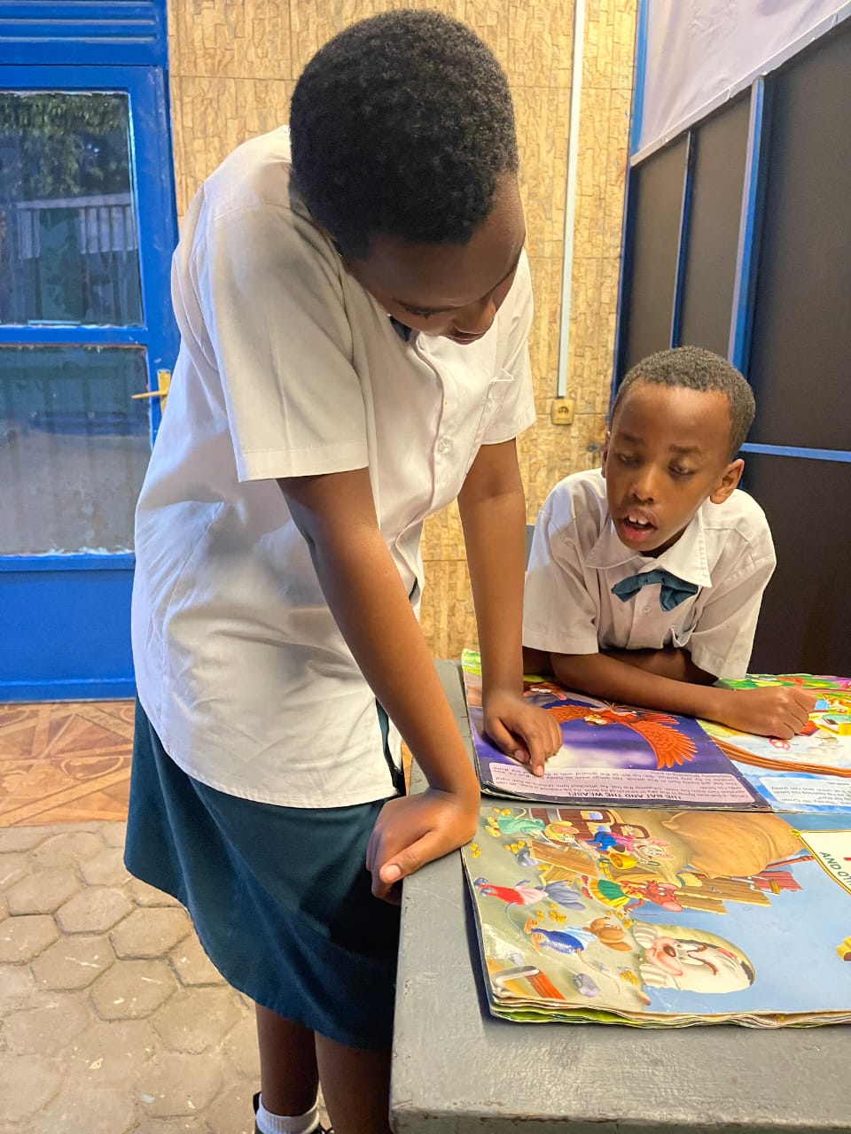 Students in uniform reading a book together