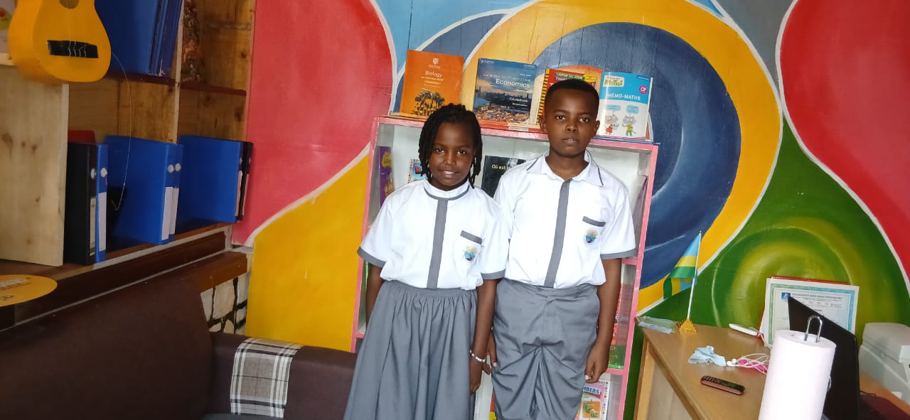 Two students in uniform by the reading corner