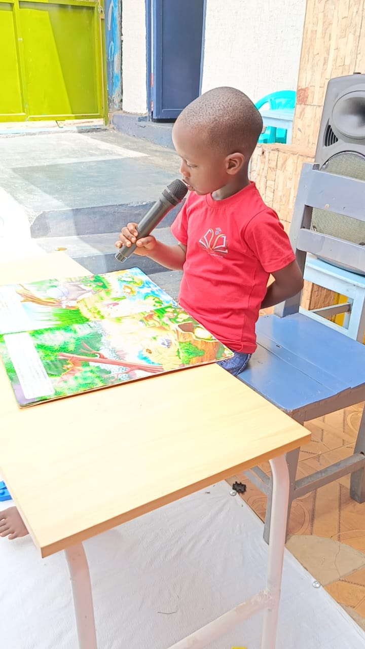 Child reading a storybook with a microphone
